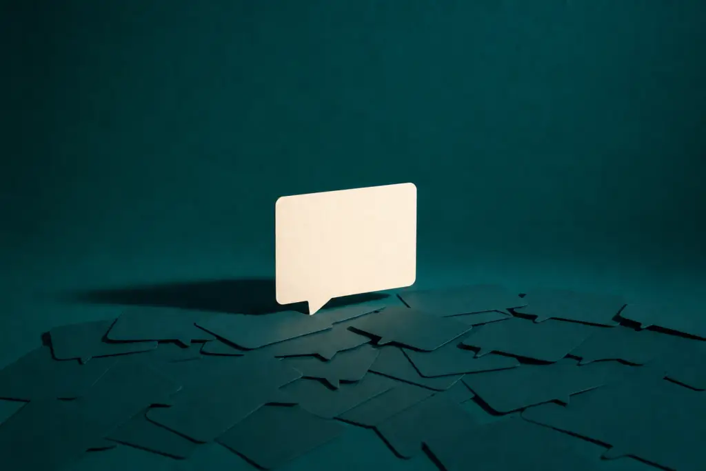 A pale paper speech bubble standing on a deep teal surface scattered with fragments, the cover for the course Get Found by AI Search