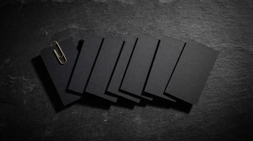 Seven blank black cards fanned in a row with a brass paperclip on dark slate, the cover for the course Create a Week of Content in One Afternoon with AI