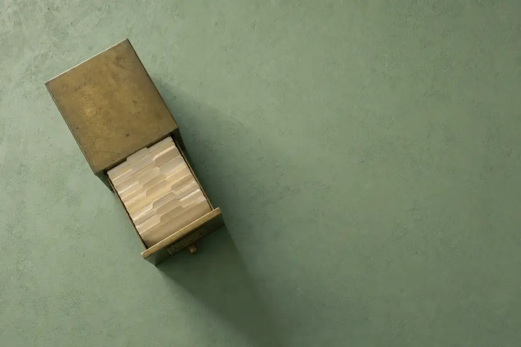 An open wooden card index box on a sage green surface, the cover for the course Your AI-Powered Second Brain