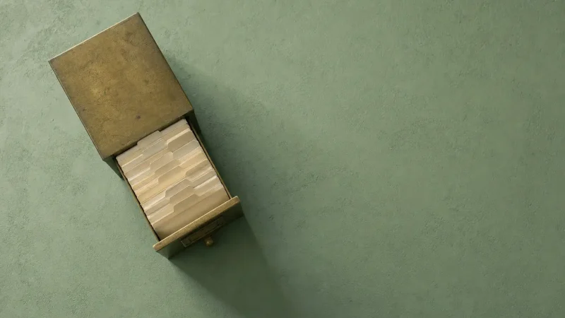 An open wooden card index box on a sage green surface, the cover for the course Your AI-Powered Second Brain